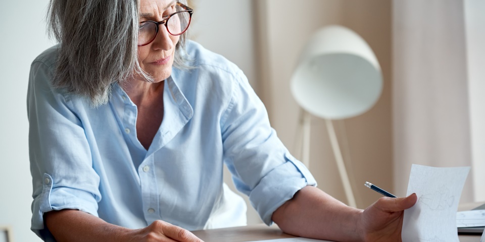 Lesende Frau am Büroschreibtisch