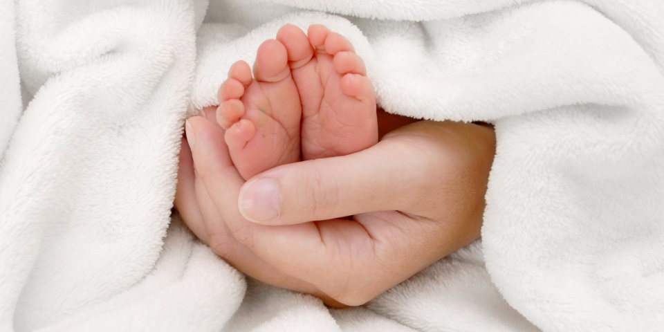 Mutter hält Füße ihres Baby in die Kamera